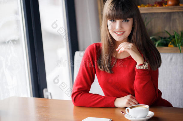 一个女孩在咖啡馆的桌子上<strong>喝了</strong>一杯热茶