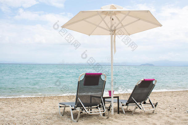 蓝色的大海和白色的沙滩，有沙滩椅和雨伞，GR