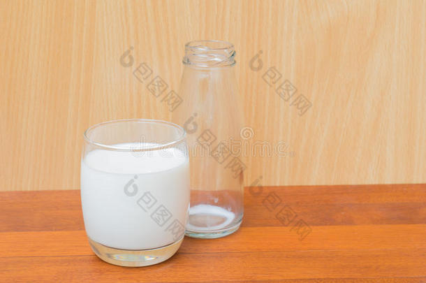 一杯<strong>牛奶</strong>和<strong>一瓶</strong>空<strong>牛奶</strong>在木背上