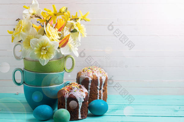 五颜六色的春花，复活节蛋糕和鸡蛋在木制<strong>背景</strong>上