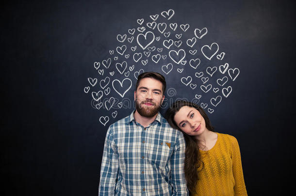 一对美丽的夫妇站在黑板上，画着一颗心