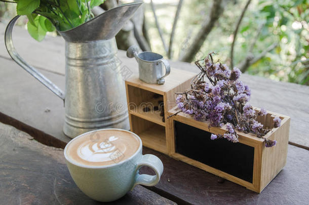 一杯咖啡与拿铁艺术在木桌上的复古风格