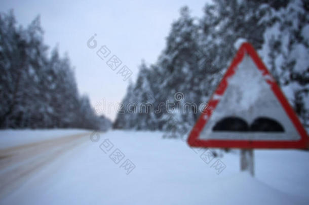 模糊的图像雪冬森林路线。 交通标志粗糙的道路