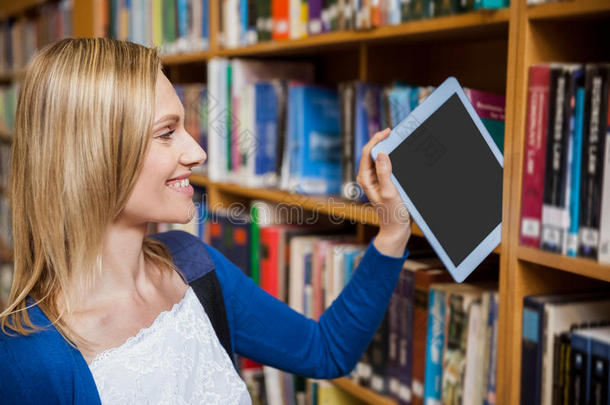 女学生在书架上整理平板电脑