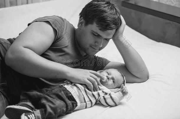 黑白相间的父亲和新生儿躺在床上的肖像