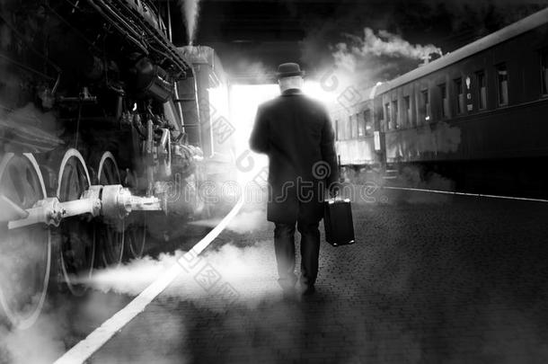 黑白照片的人穿着老式衣服走在火车站