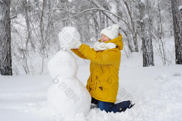 冬天公园里的美女正在<strong>堆雪人</strong>。