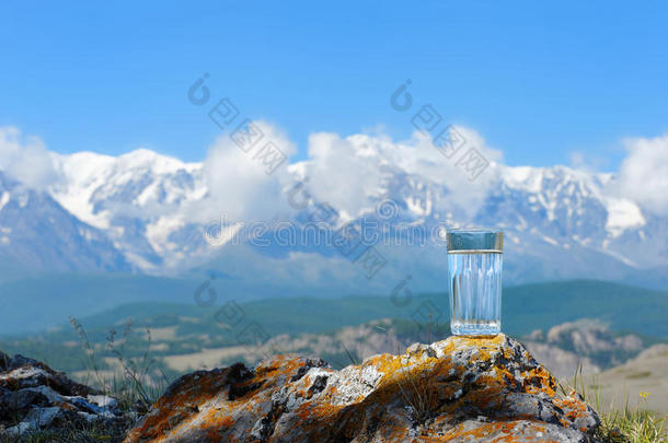 雪山背景上的一杯纯净水。