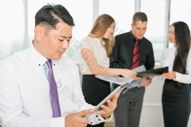 高管亚洲老板使用平板电脑与他的业务团队