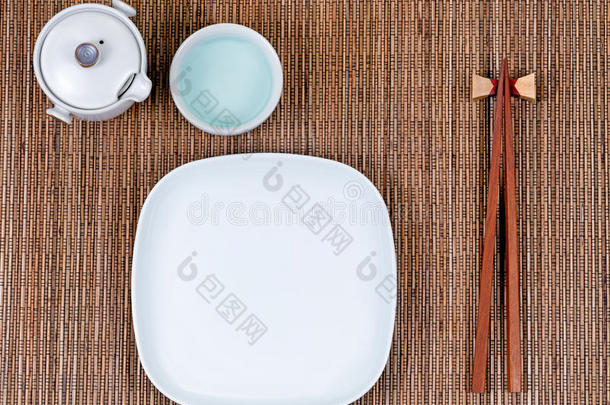 竹席与传统的亚洲器皿加上白色餐盘和茶