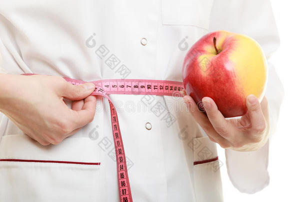 医生专家拿着水果苹果测量腰部