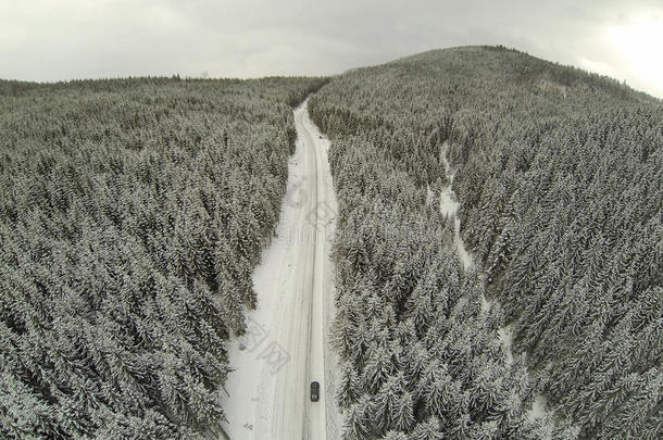 空中拍摄白雪覆盖的道路在乡村喀尔巴阡山与汽车在路上