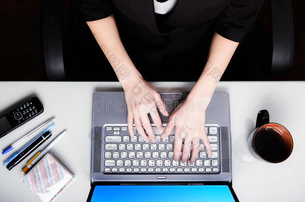 特写现代工作场所。 上面的风景。 在笔记本电脑工作的女人。
