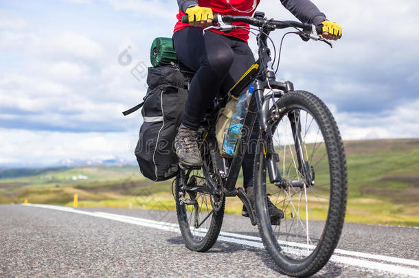 在冰岛阳光明媚的夏日，骑自行车的人骑在路上。 旅行和运动图片
