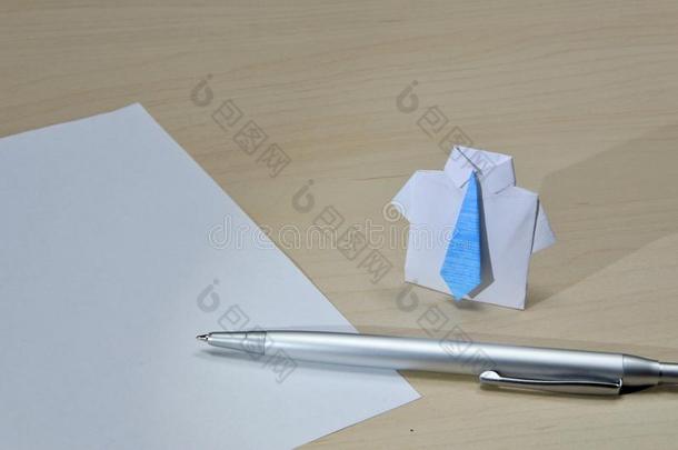 在桌子上的纸和笔附近用蓝色领带特写折纸套装的照片