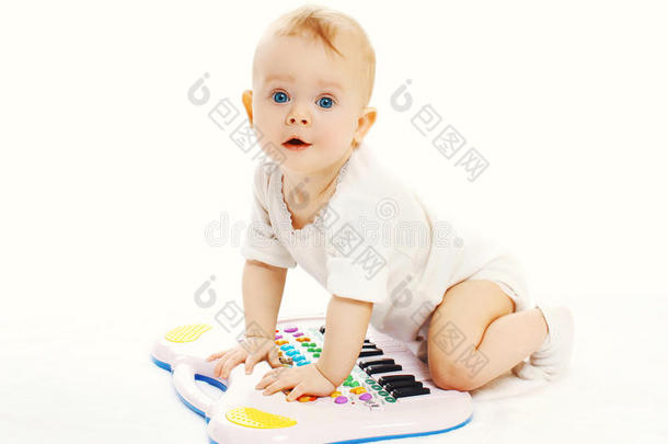 婴儿在白色背景上玩玩具钢琴