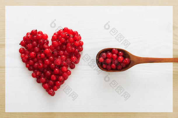 心形的蔓越莓和<strong>木板</strong>上装满<strong>浆果</strong>的勺子