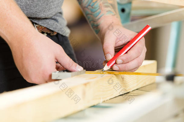 木匠在锯之前测量木板的长度