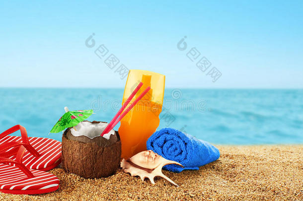 拖鞋，防晒霜和椰子鸡尾酒在海滩上。