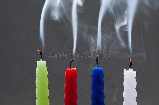 彩色熄灭的蜡烛，灰色背景上有白色的烟雾。 <strong>四件</strong>：绿色，红色，蓝色，白色。 褪色