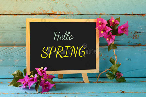 黑板上的蓝色木架上有“你好春天”这句话