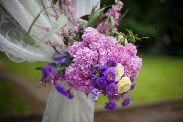 美丽的白色婚礼通道牌坊与紫色的花朵特写