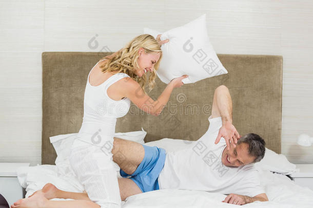 可爱的夫妇玩枕头大战