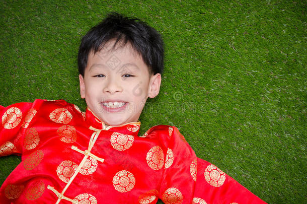 穿着<strong>中国服装</strong>的男孩躺在草地上