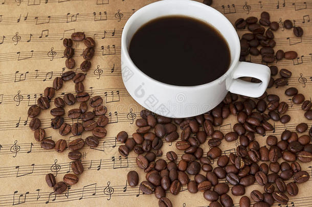 一杯黑咖啡放在肉桂和豆子的<strong>床单</strong>音乐上