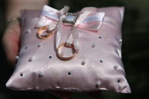 婚礼用的金戒指在装饰枕头上