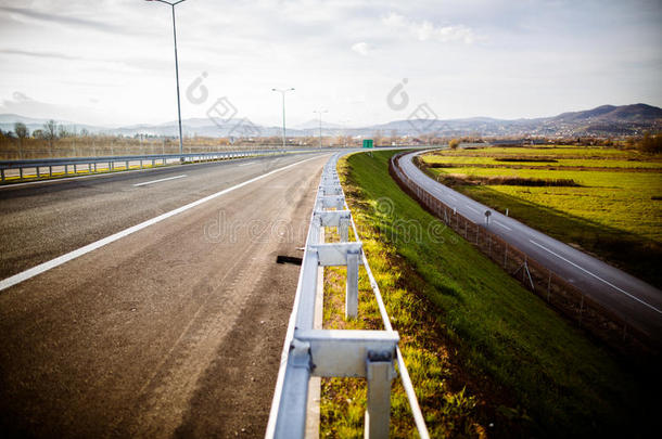 高速公路在阳光明媚的日子里，经过风景优美的绿色草地，高速公路长途行驶，沥青公路在农村场景中使用土地