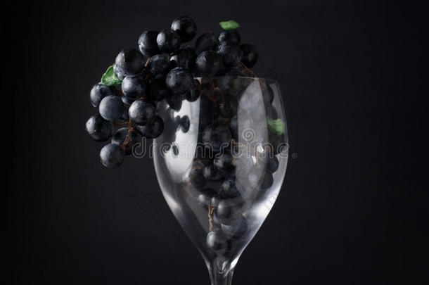 红酒杯里的葡萄挂在黑暗的背景上