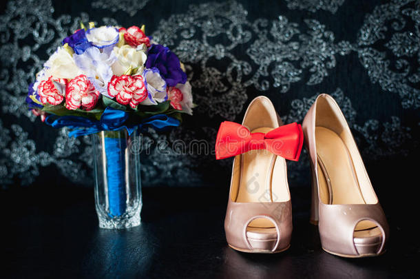婚礼花束的特写玫瑰，婚礼花在黑色桌子上的酒店房间里，白色的鞋子