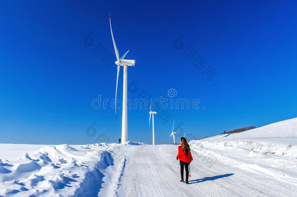 美丽的女孩走在冬天的天空景观和冬天的道路与雪。