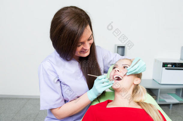 友好的牙医妇女检查和清洁牙齿