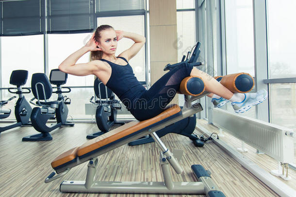 美女在体育健身房做压力健身运动。