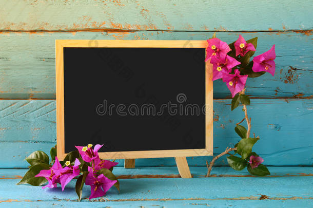 空白黑板旁边美丽的紫色地中海夏季花卉。 陈年过滤。 复制空间