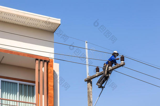 电工在电力杆上修理电线。
