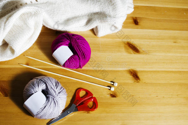 桌子上的毛线球和木制编织针。