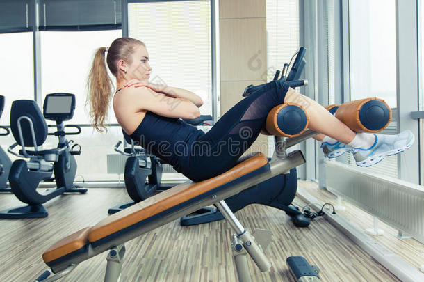美女在体育健身房做压力健身运动。