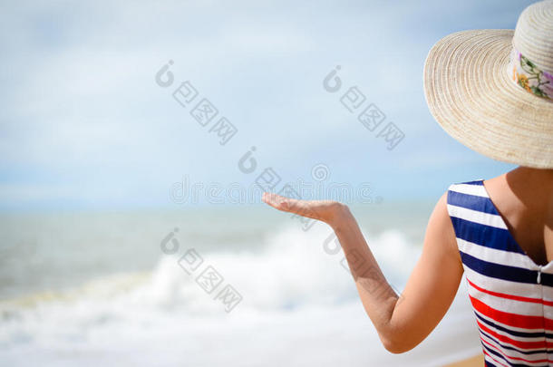 以夏日大海为背景的优雅女子手握手掌的背影