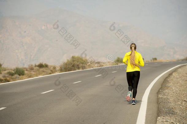 沙漠山路<strong>柏油路上</strong>跑的年轻美女背影