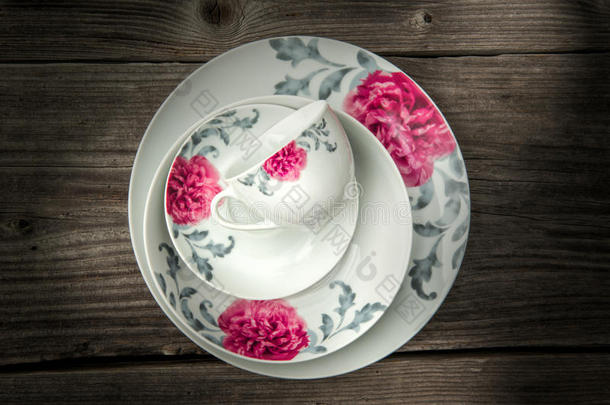 餐瓷一套<strong>盘子</strong>和一个杯子与花卉装饰在木制背景，产品<strong>摄影</strong>