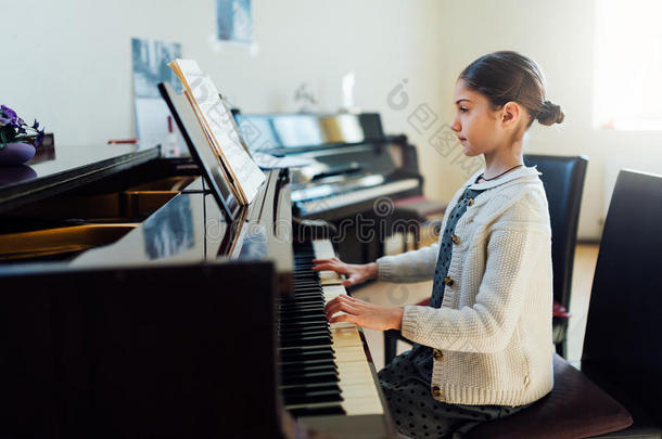 在<strong>艺术学校</strong>弹钢琴的漂亮女孩