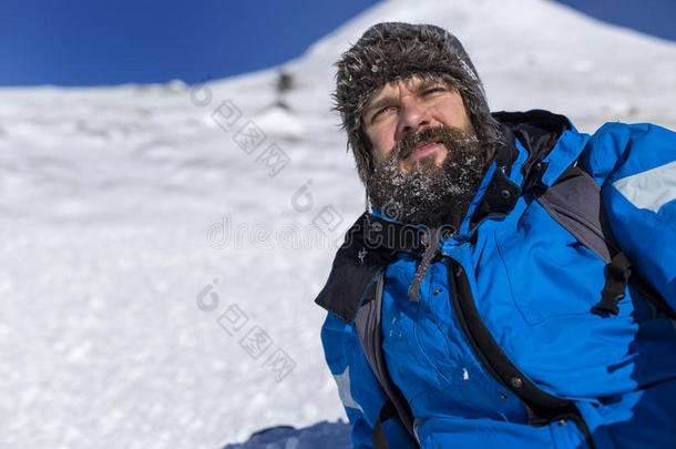 胡须徒步旅行者在冬天爬山时休息