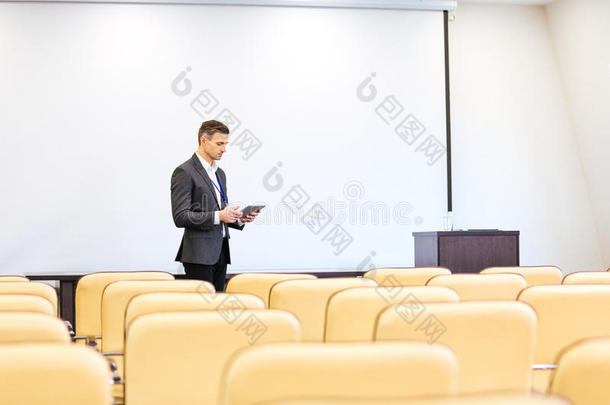 集中演讲者在空会议室用平板电脑重复演讲