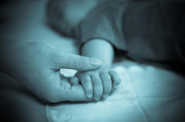 亚洲婴儿的手放在母亲的手上