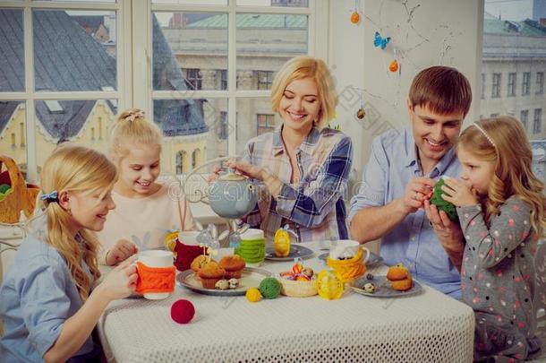 快乐的家庭享受乐趣，享受调味茶和纸杯蛋糕。