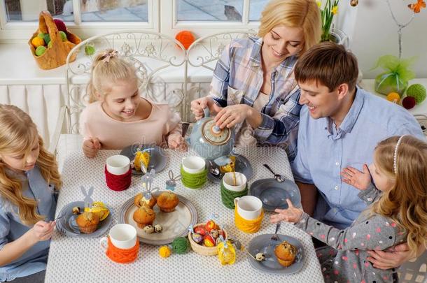 快乐的家庭享受乐趣，享受调味茶和纸杯蛋糕。
