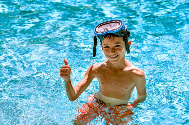 男孩，孩子，8岁，游泳池里的肖像，快乐，有趣，明亮的一天，潜水镜，竖起大拇指
